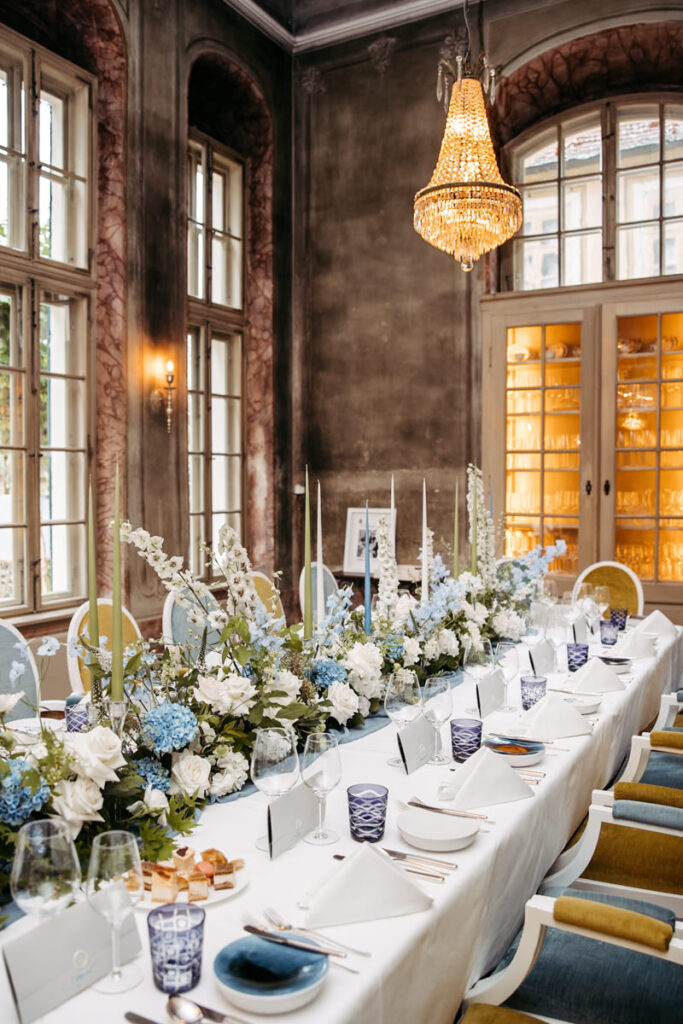 Elegant gedeckte Hochzeitstafel in Villa Sorgenfrei bei Dresden mit blauen und weißen Blumen, Kerzen und edlem Geschirr.